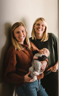 Deux femmes avec un bébé dans les bras.